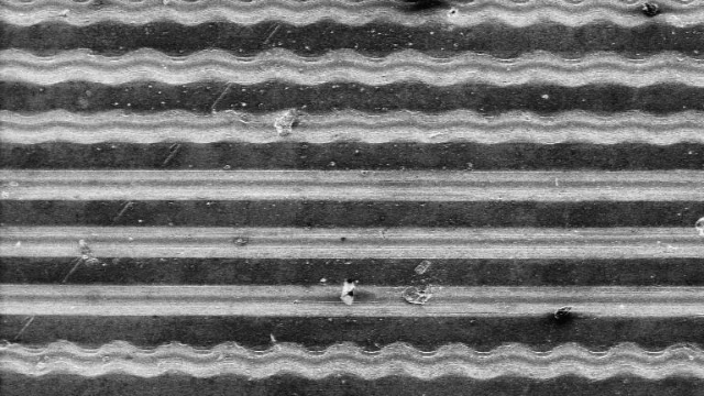 Schallplatte unter dem Rasterelektronenmikroskop<br>Ausschnitt: 200 μm
